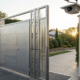 An automated access control gate system with an integrated security camera at a property entrance.
