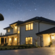 A house at night secured by a home alarm system with an outdoor security camera.