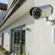 An affordable home security system with an outdoor camera and keypad on a modern house.
