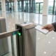 A person uses a keycard for a commercial building's access control system.