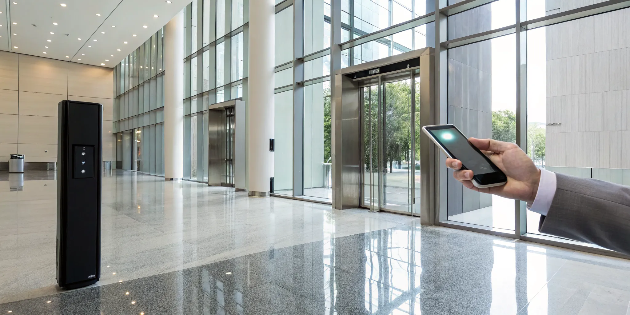A person uses a smartphone for integrated access control with a security alarm system.