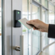 Small business employee using a key card for office entry with an access control system.