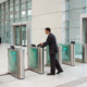 Man using an access control gate in a commercial building to meet security regulations.