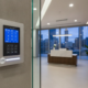 Modern low-voltage security alarm keypad on a wall in a sleek Atlanta business office lobby