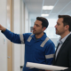 Fire alarm technician reviewing a commercial building fire alarm panel during a replacement planning visit
