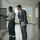Technician reviewing a commercial fire alarm control panel with a facility manager